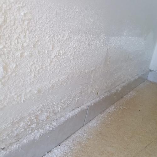 Salpêtre visible au bas d’un mur dans une maison